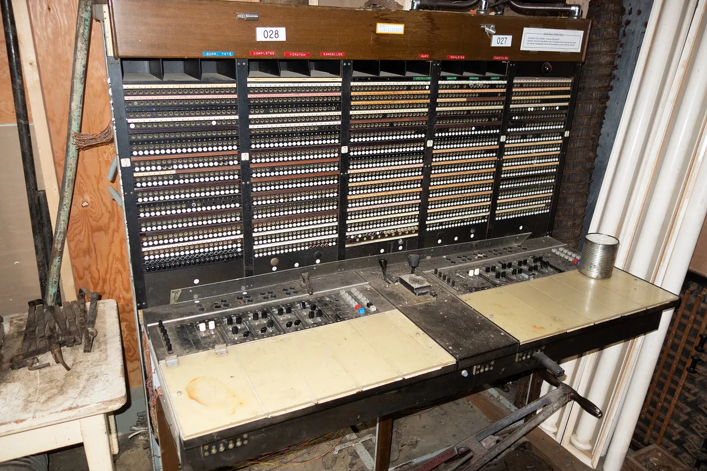 Centralino telefonico d'epoca con file di spie e jack e il piano di lavoro dell'operatore